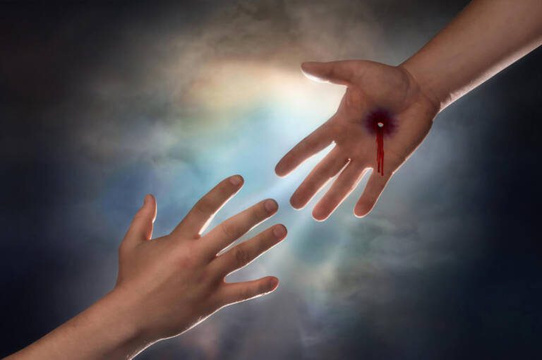 Two hands reaching towards each other in the sky with a bloody hole in one hand